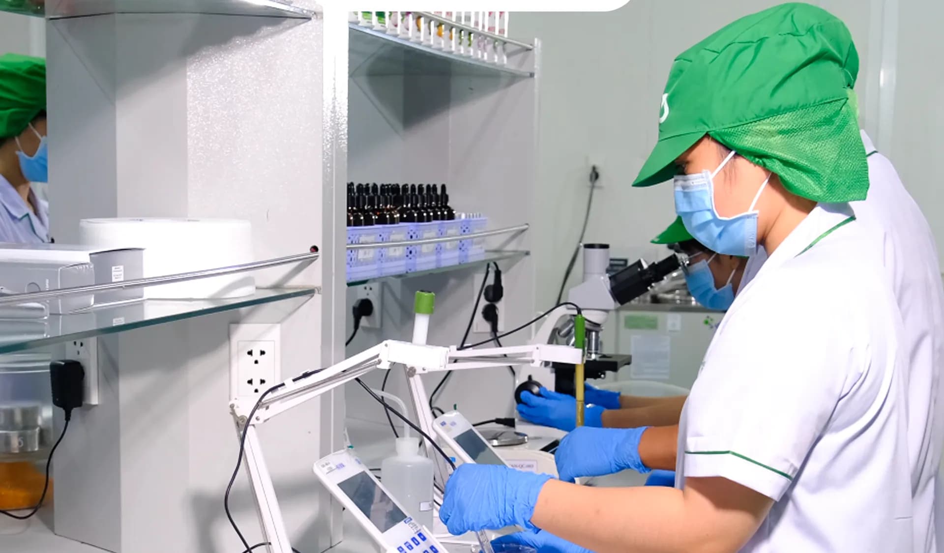 A laboratory technician works with beverage samples and testing equipment.